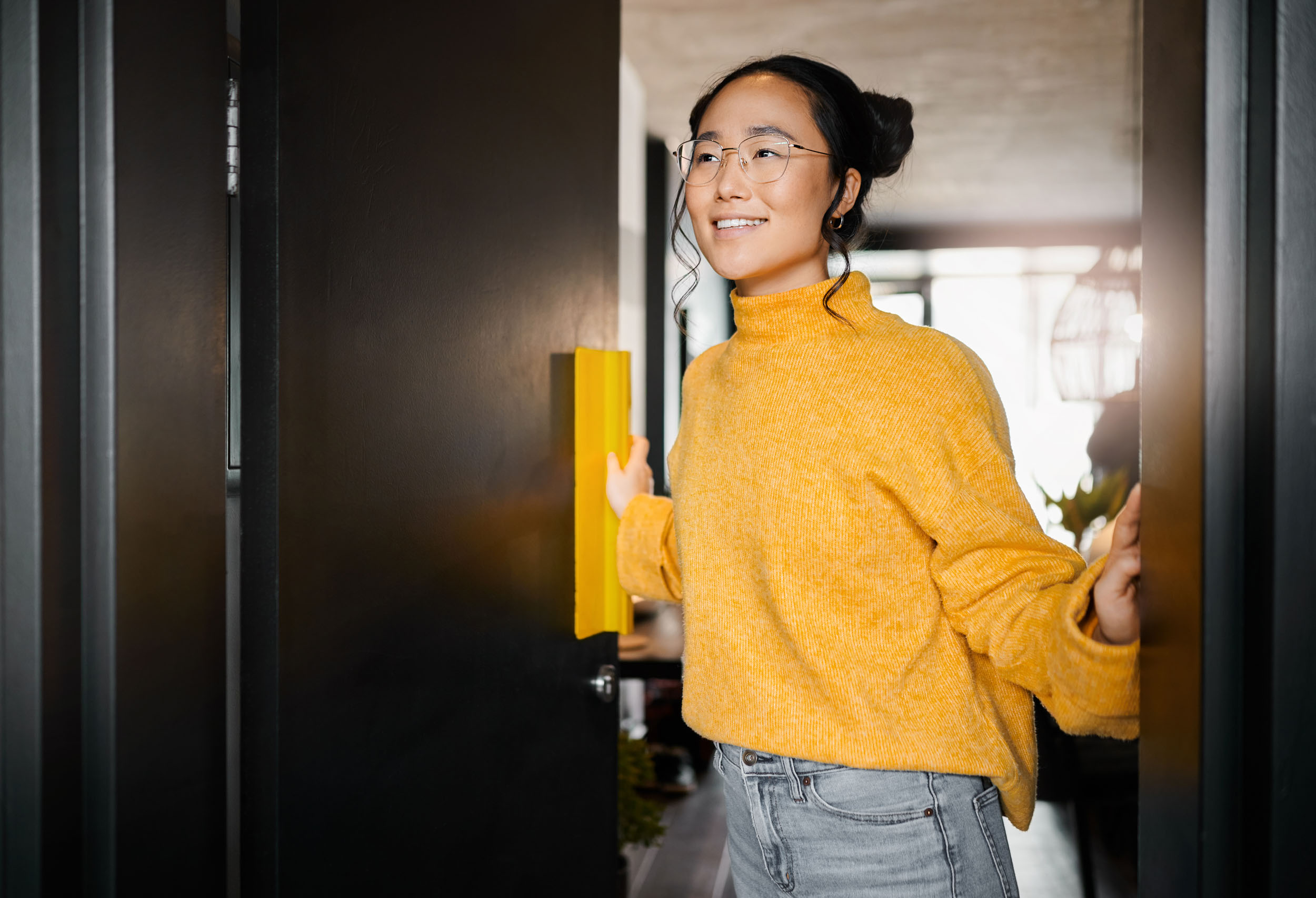 07 Girl Opening Apartment Door in Yellow Sweater and Glasses